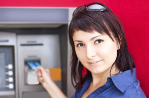 Woman withdrawing money from credit card at ATM